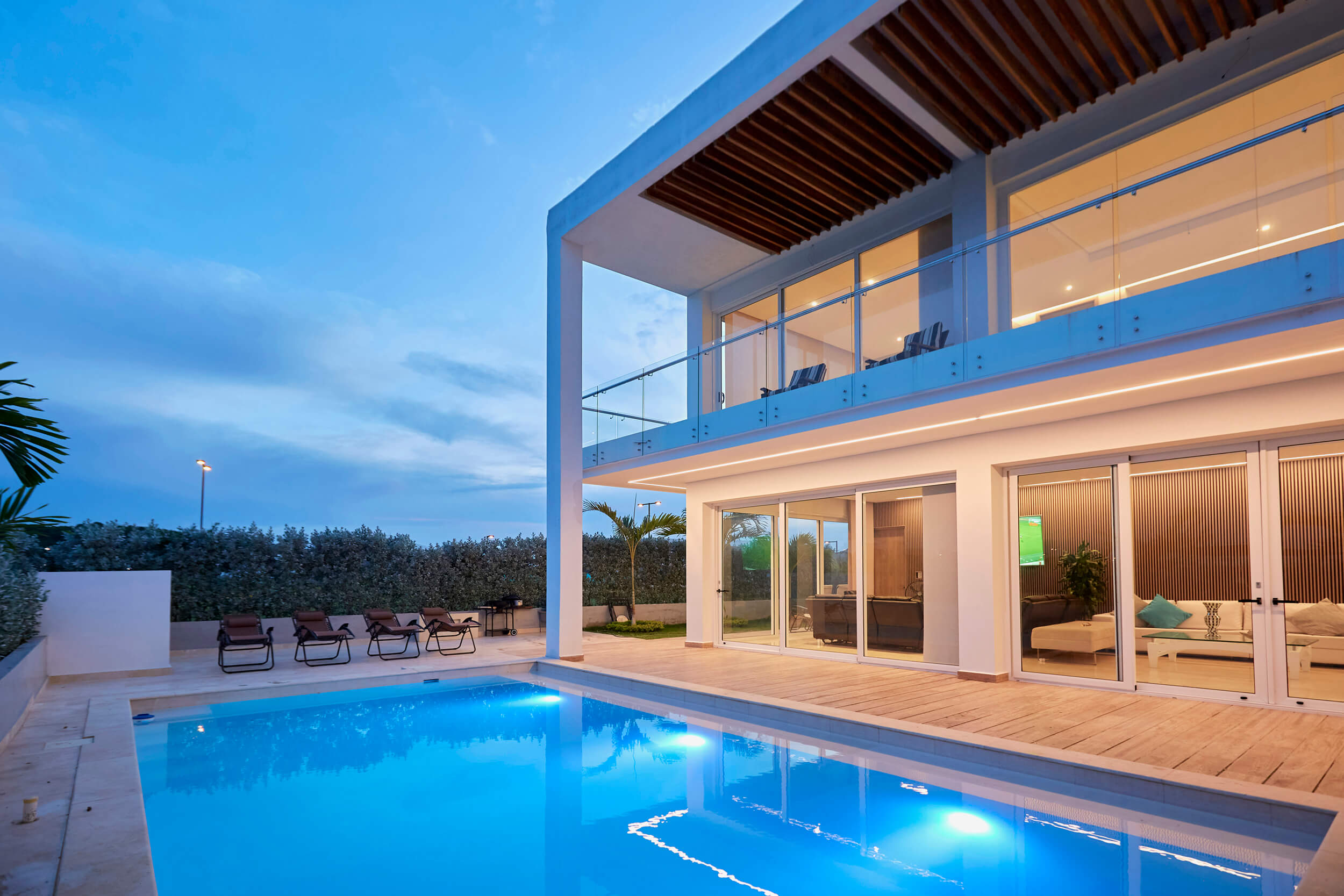 Vista nocturna de Casa Monserrat 1A con iluminación arquitectónica y piscina en Cartagena.