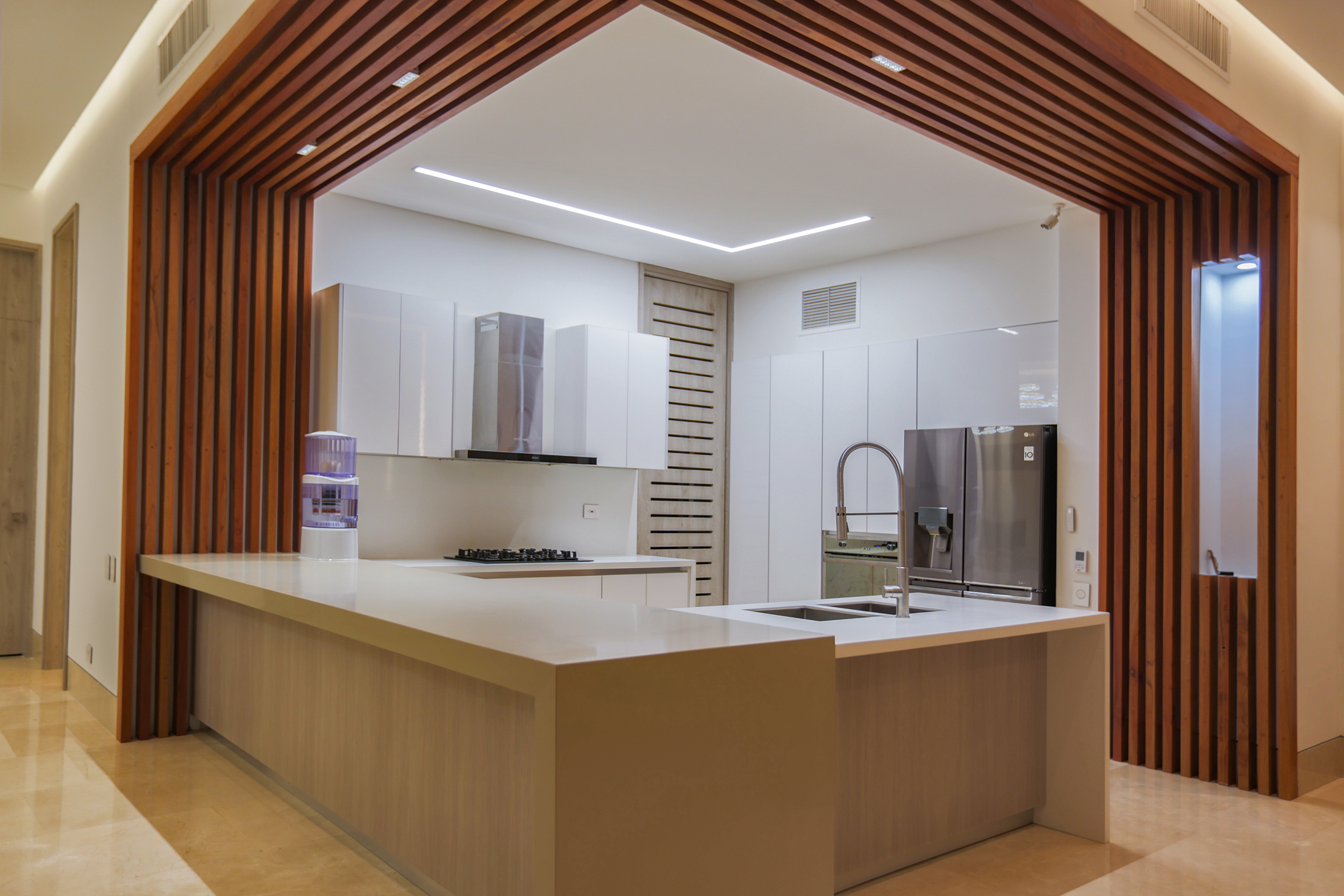 Cocina abierta de Casa Sarria 31 03 enmarcada por listones de madera.