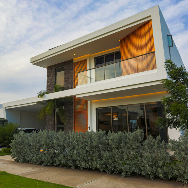 Fachada frontal Casa Sarria 31 03 — volúmenes blancos, listones de madera y revestimiento en piedra