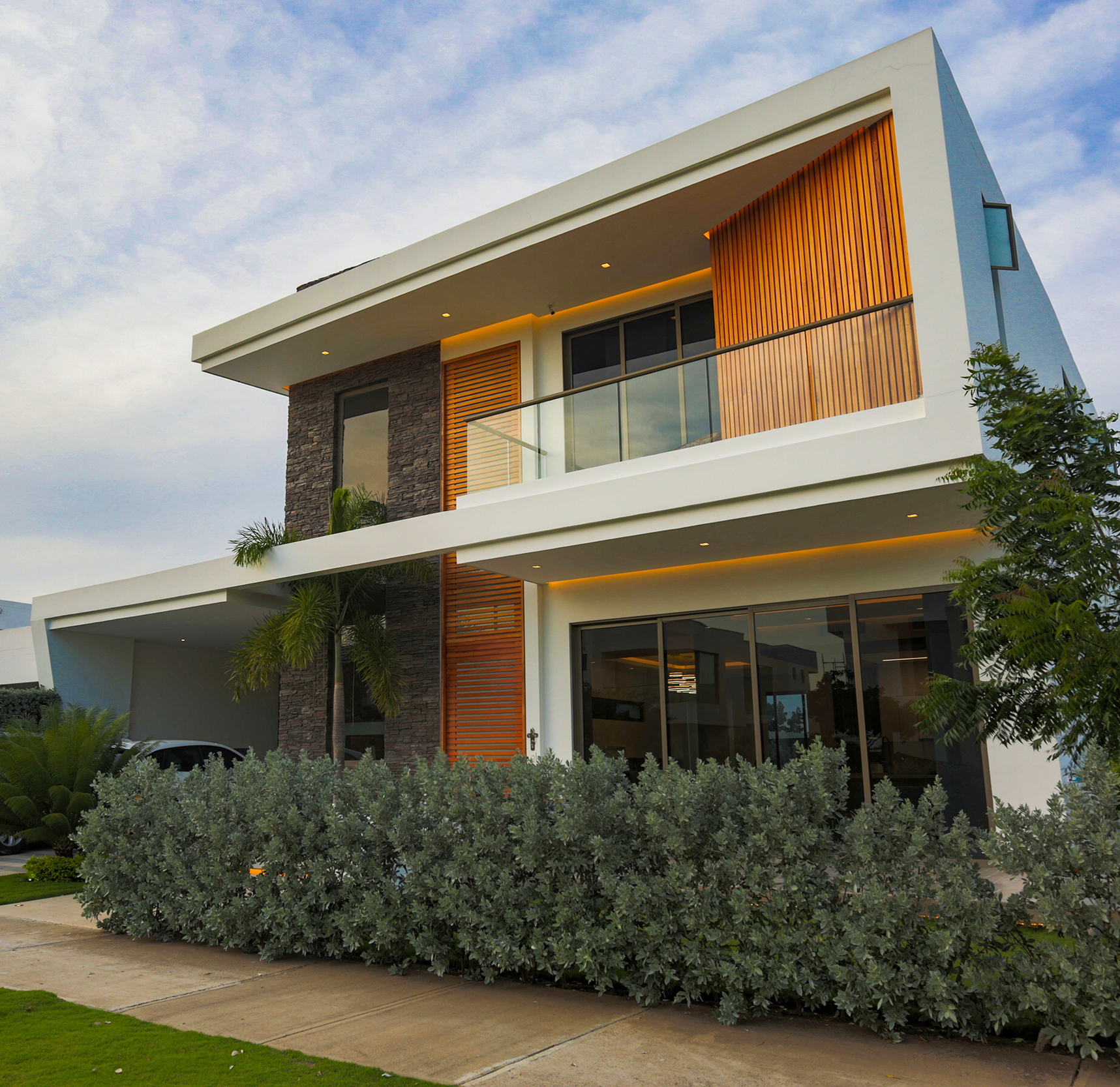 Fachada frontal Casa Sarria 31 03 — volúmenes blancos, listones de madera y revestimiento en piedra