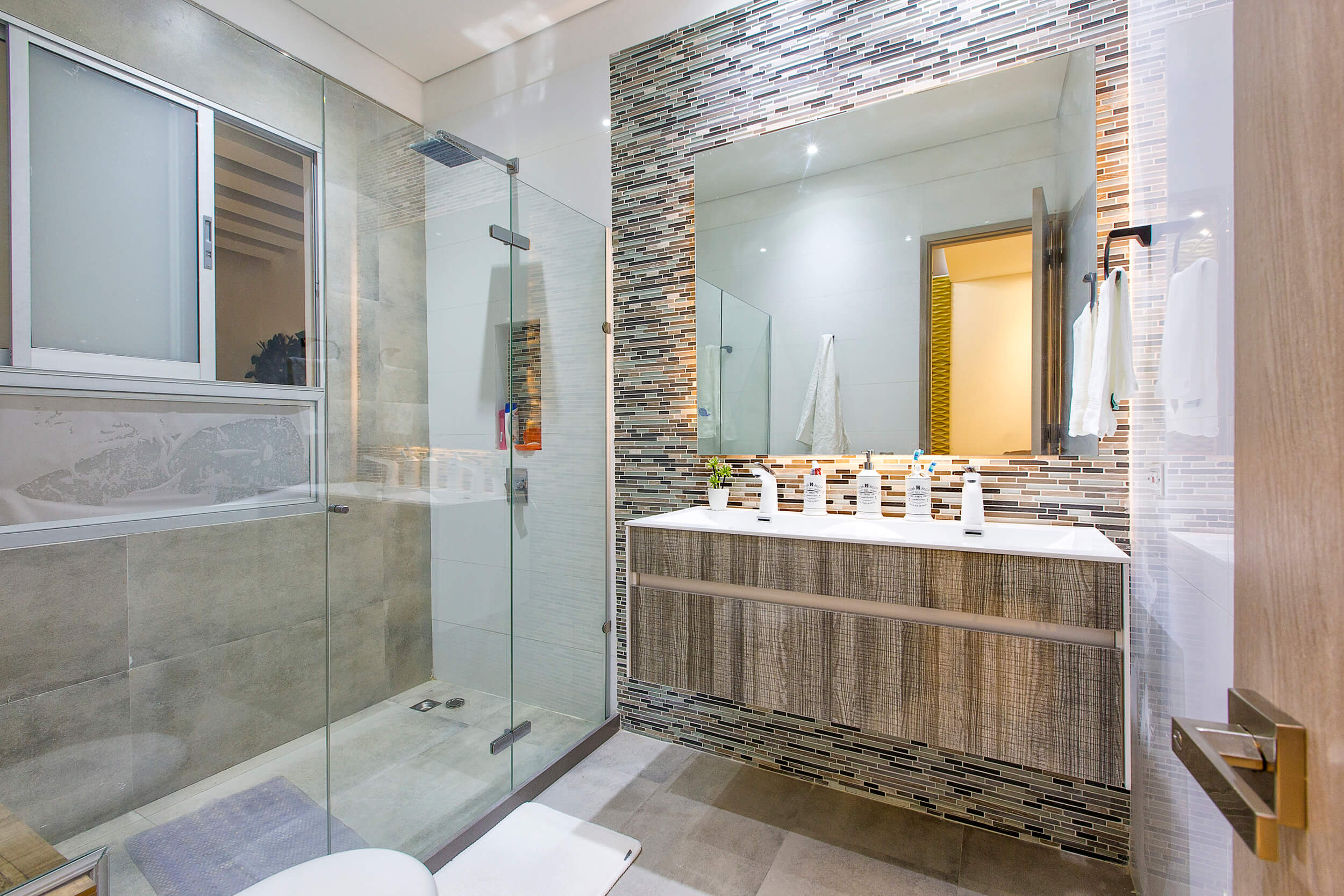 Baño principal con mosaico y mampara de vidrio — acabados para remodelaciones Cartagena