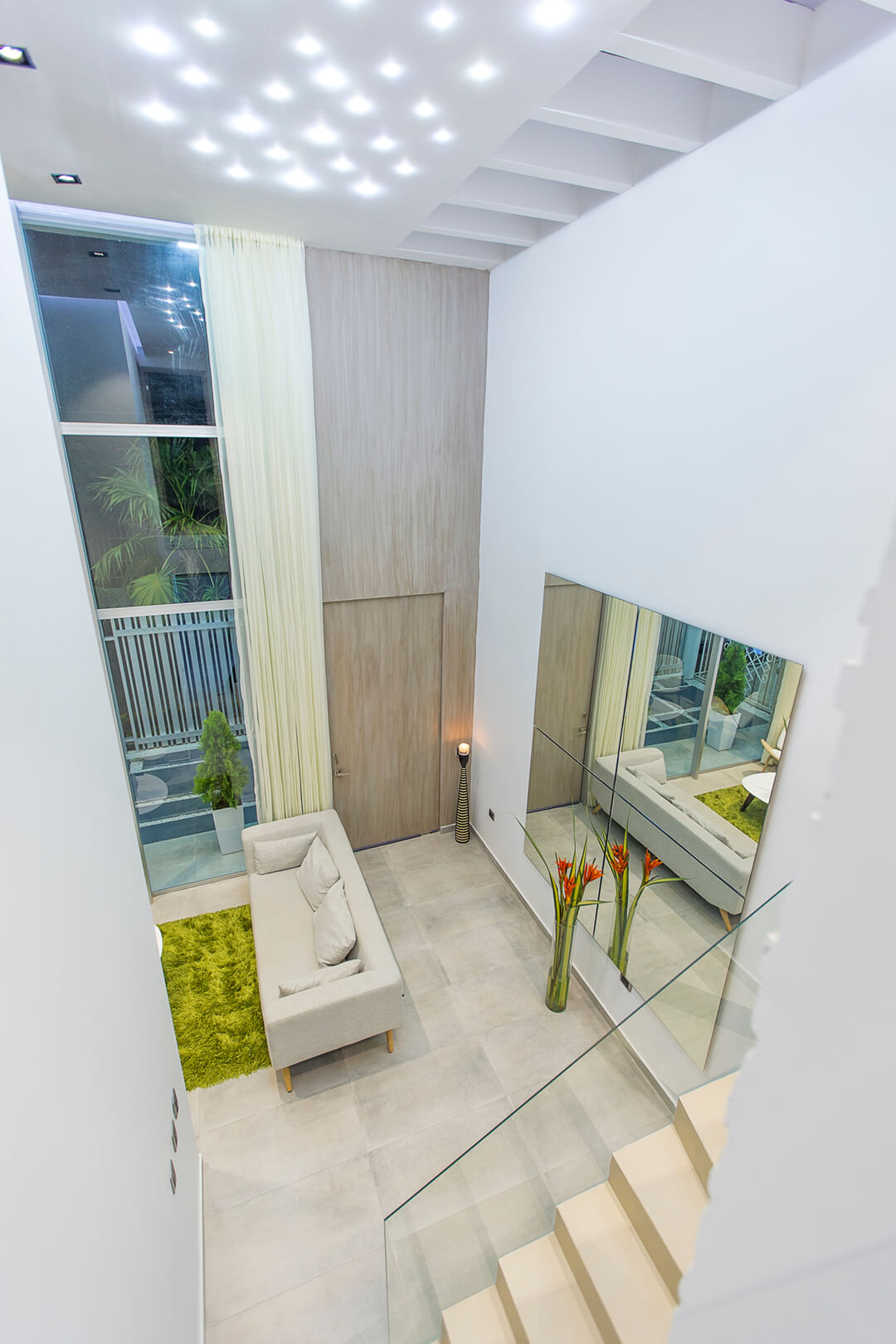 Sala doble altura con muro texturizado y mobiliario minimalista — Casa MB, diseño de interiores Cartagena