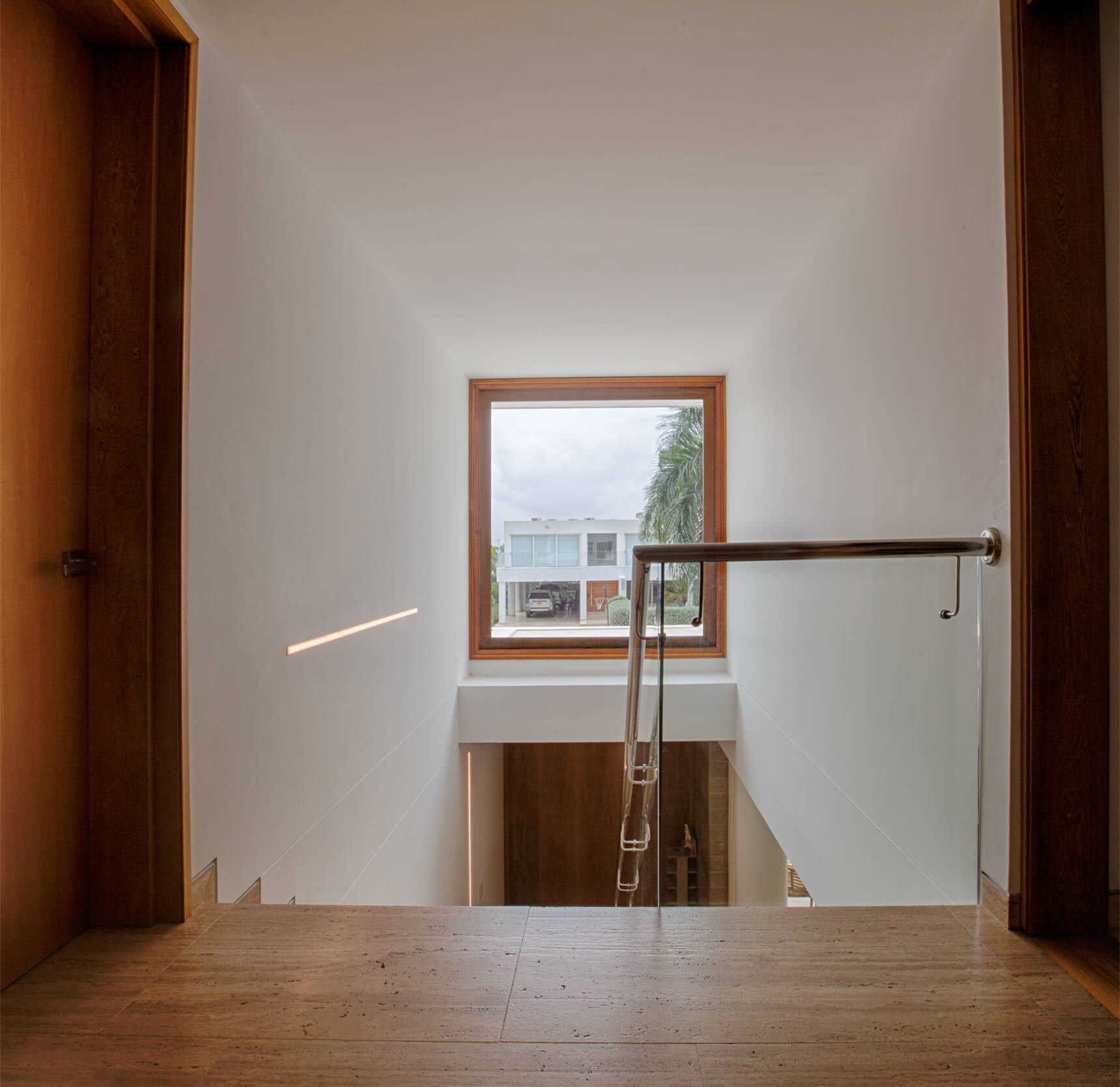 Diseño interior contemporáneo con escalera moderna, barandas en vidrio y luz natural en residencia de lujo