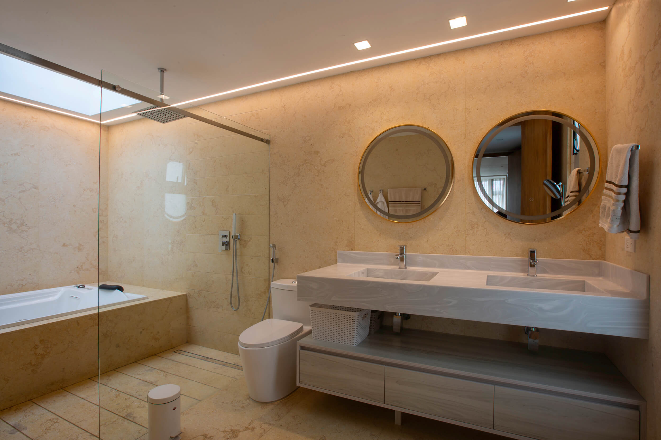 Baño contemporáneo de lujo con revestimientos en piedra natural, lavamanos doble y diseño tipo spa minimalista. Rediseño interior por Topp Create