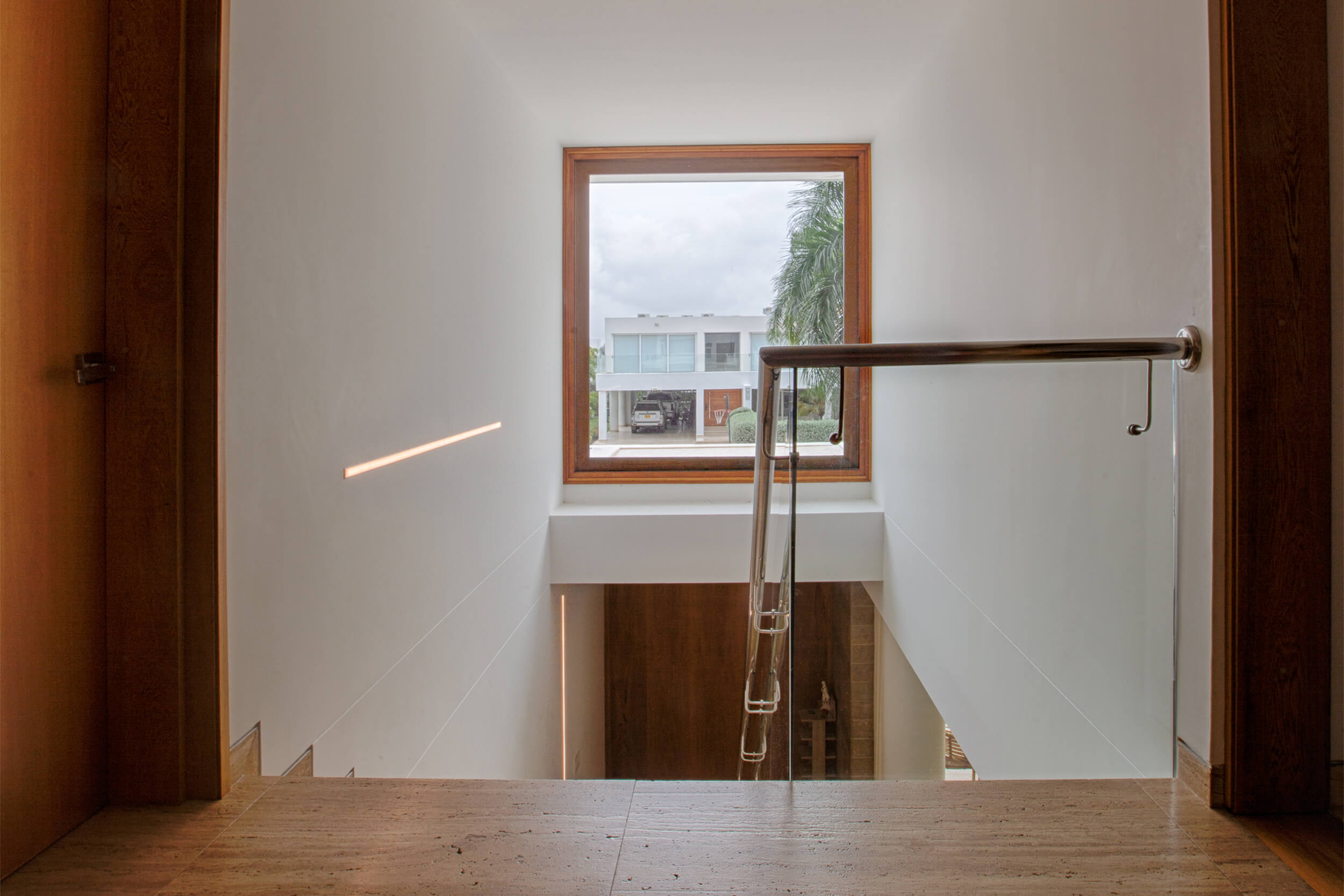 Escalera rediseño interior minimalista con iluminación arquitectónica LED, detalles en madera y diseño contemporáneo residencial.