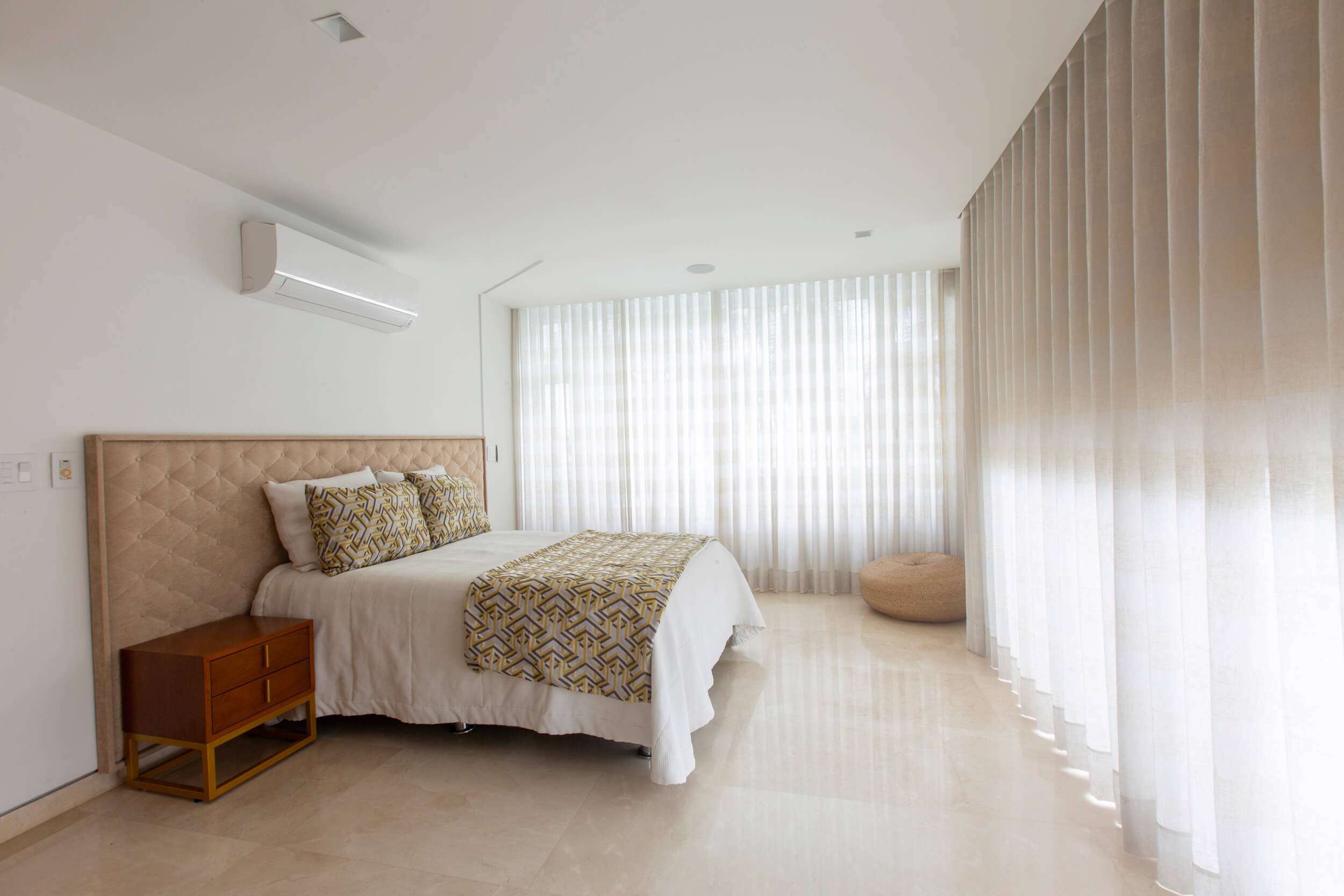 Habitación minimalista contemporánea con iluminación natural, cortinas translúcidas y diseño interior elegante.