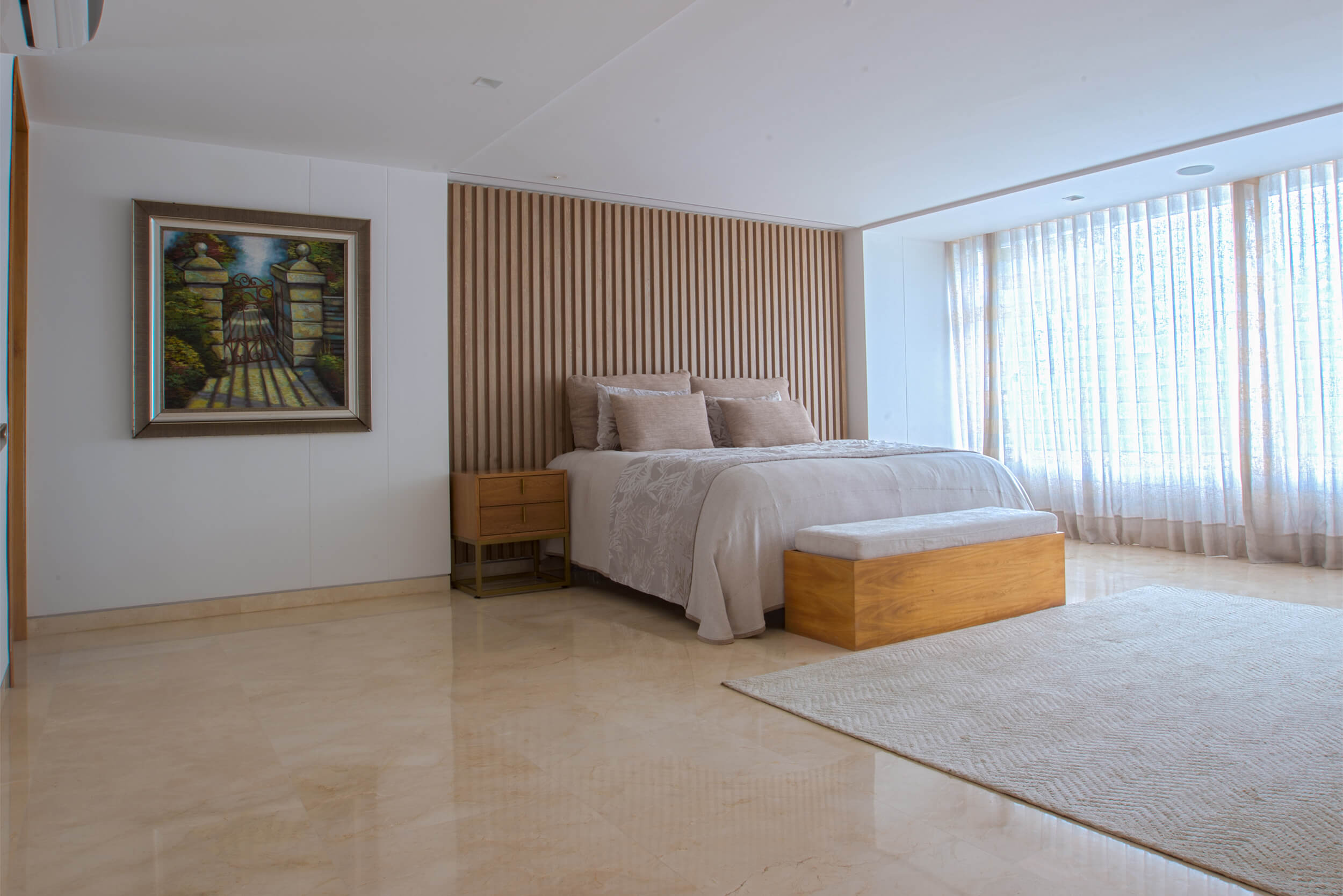 Habitación principal contemporánea con panelado en madera, iluminación natural y diseño interior minimalista de lujo.