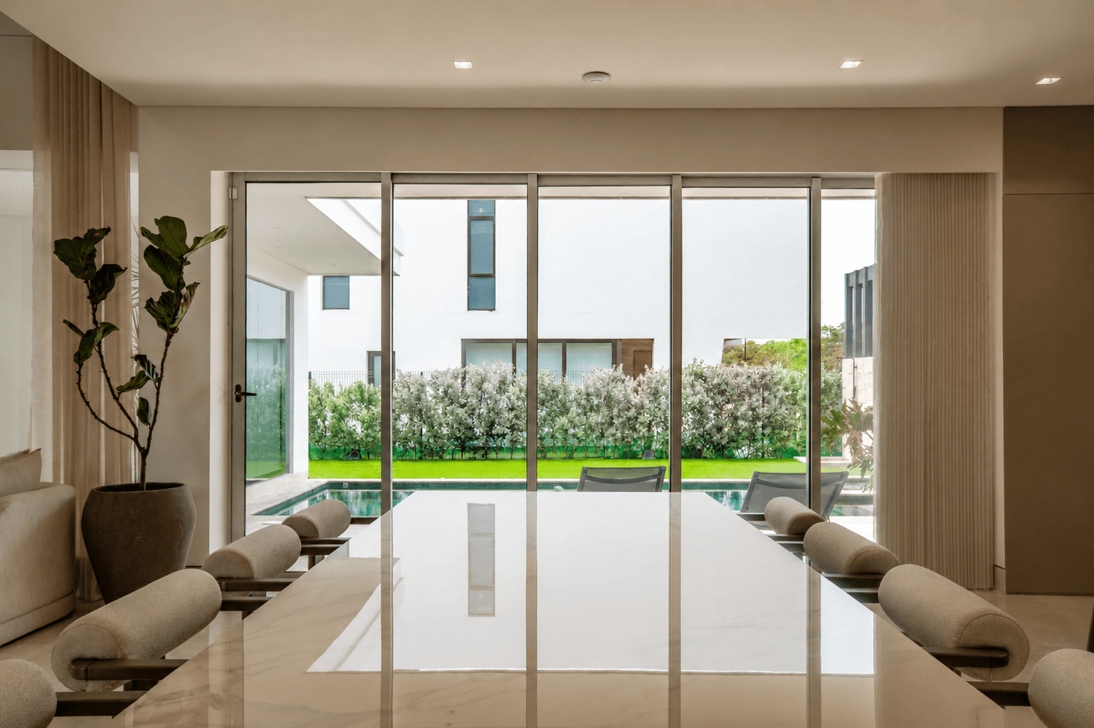 Diseño residencial moderno con comedor elegante y vista hacia la piscina exterior